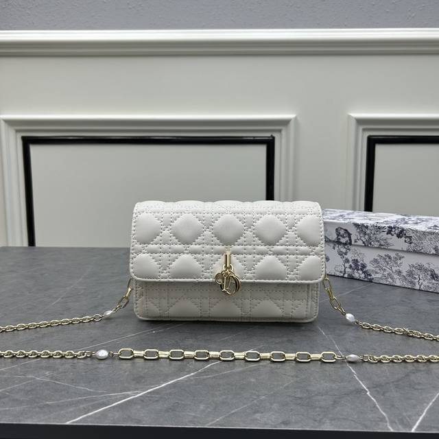 配盒子dior新款 这款 Lady Dior 手拿包设计精巧 空间宽敞 采用白色羊皮革精心制作 饰以藤格纹缉面线 点缀以 D.I.O.R. 吊饰 彰显时尚经典的