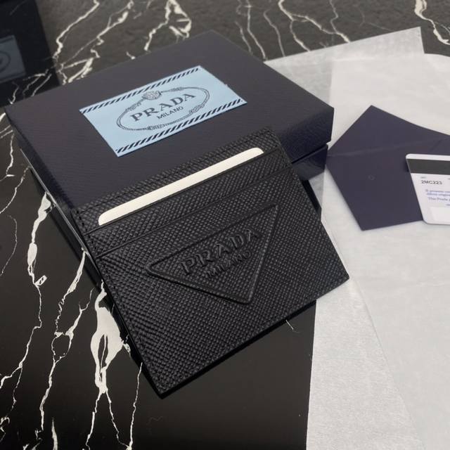 顶级原单 新款卡片夹2Mc223 这款saffiano皮革卡片夹设计简约 风格鲜明 夹身配有主口袋和六个卡槽 标志性的同色压花三角形徽标彰显品牌特色 喜欢的宝宝