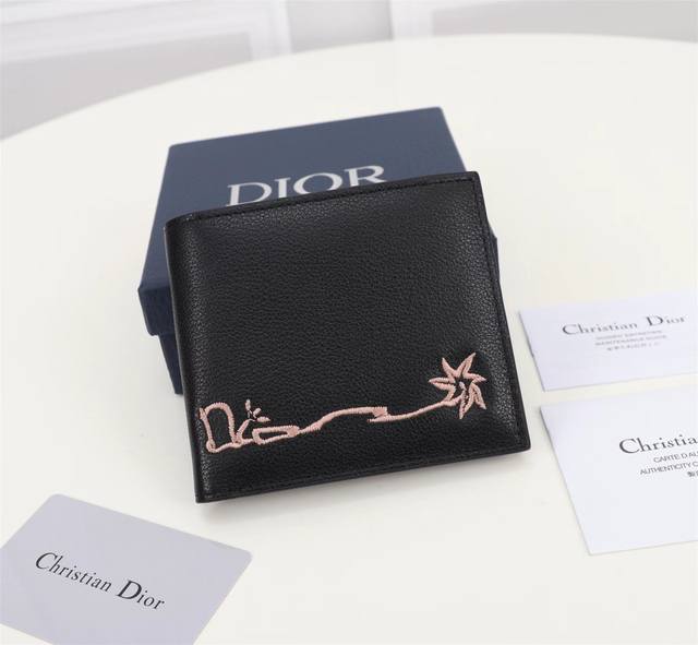 Dior 男士短款钱夹双折款式 这款钱包来自dior与cactus Jack的尊享联名系列 是一款精巧高雅的配饰 采用黑色粒面牛皮革精心制作 饰以对比鲜明的缉面