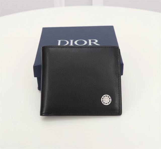 Dior 男士短款钱夹 采用黑色光滑牛皮革精心制作 饰以金属覆层黄铜cd Button标志 双折款式 搭配黑色头层牛皮 内置1个双层现金隔层 2个票据隔层和8个