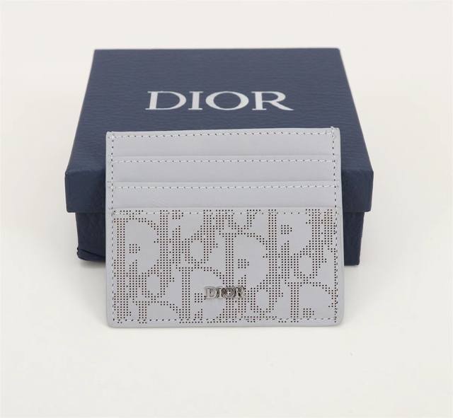 灰色oblique Galaxy印花效果皮革制作 镂空的光滑牛皮革搭配反光里料 细长而小巧的 Dior Oblique 卡夹便于携带卡片和现金 两侧分别设有3个