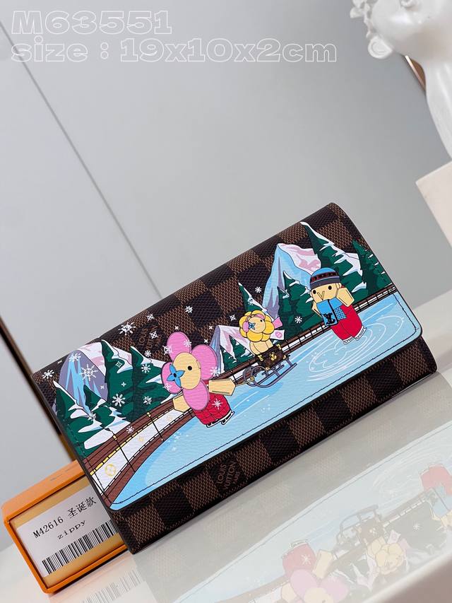 顶级原单复刻m6 1圣诞款 M40722 這款sarah錢包的翻蓋以damier Ebene塗層帆布製成 玩味十足的印花圖案描繪路易威登吉祥物vivienne與