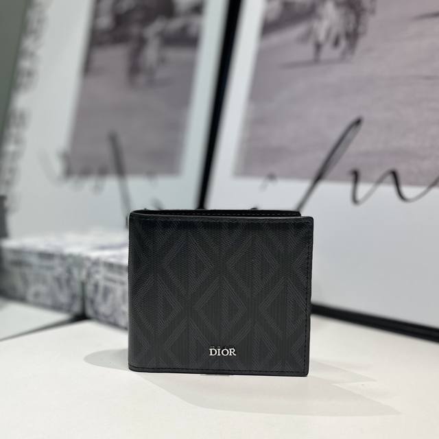 S027 这款钱包彰显优雅气质 采用迪奥灰 Cd Diamond 图案帆布精心制作 从 Dior 档案汲取灵感 饰以同色调光滑牛皮革细节 内部设有一个双层现金隔