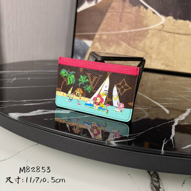 顶级原单 M82853 本款 Monogram 帆布卡夹印有活泼可爱的品牌吉祥物 Vivienne 生动细致地描绘她与朋友在热带海滩附近乘船玩耍的场景 夹层内可