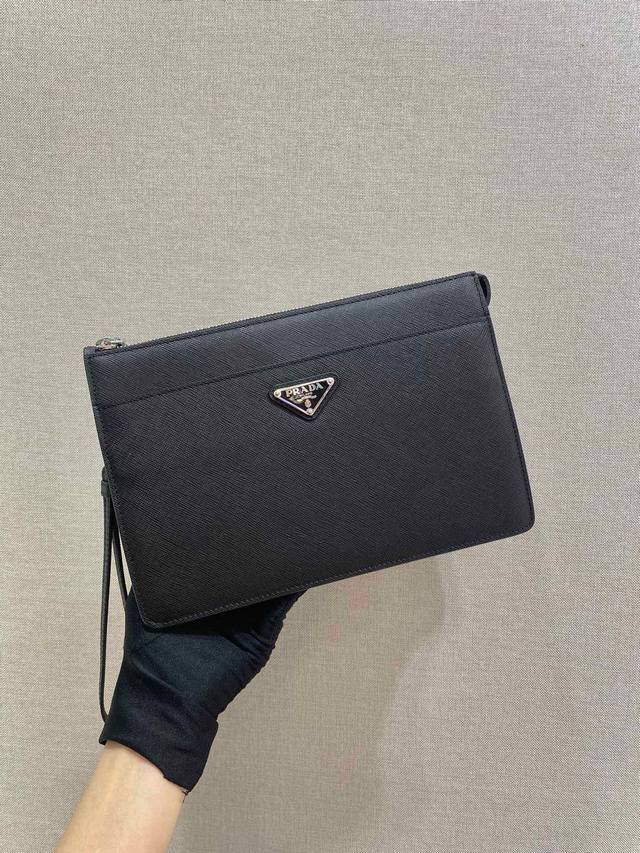 家新款手包2Vf032这款造型时尚的男士手袋配有一条可拆卸皮革腕带 三角形金属徽标点缀其上 释放独特的品牌气息 采用进口saffiano皮革材质 顶做金属配件一