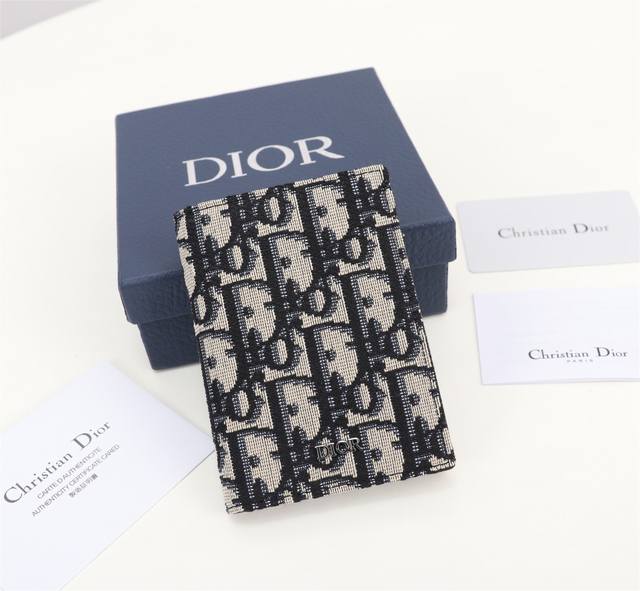 Dior男士新款双折卡夹 采用oblique 印花面料和黑色牛皮革精心制作 彰显dior的精湛工艺 实用精致 造型美观 两侧分别设有三个卡槽 另设两个可收纳现金