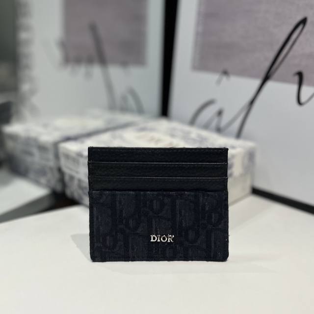 这款卡夹实用而不失优雅 采用 Oblique 印花面料和黑色粒面牛皮革精心制作 饰以金属覆层黄铜 Dior 标志 正面和背面各设有三个卡槽 顶部亦设有一个卡槽
