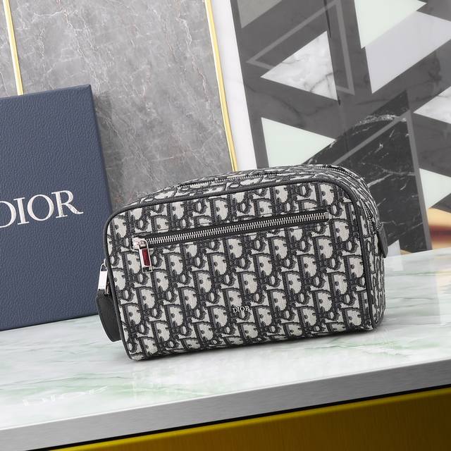 这款洗漱包融合实用功能与简约设计 采用米色和黑色 Oblique 印花面料精心制作 饰以黑色粒面牛皮革饰边 正面点缀以 Dior 标志 正面设有一个拉链口袋 一