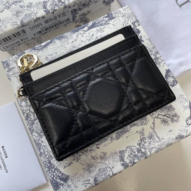 这款 Lady Dior五格卡夹是本季新品，优雅实用。采用灰色羊皮革精心制作，饰以藤格纹缉面线，点缀以可拆卸的 D.I.O.R. 吊饰。高雅精致，设有五个卡槽，