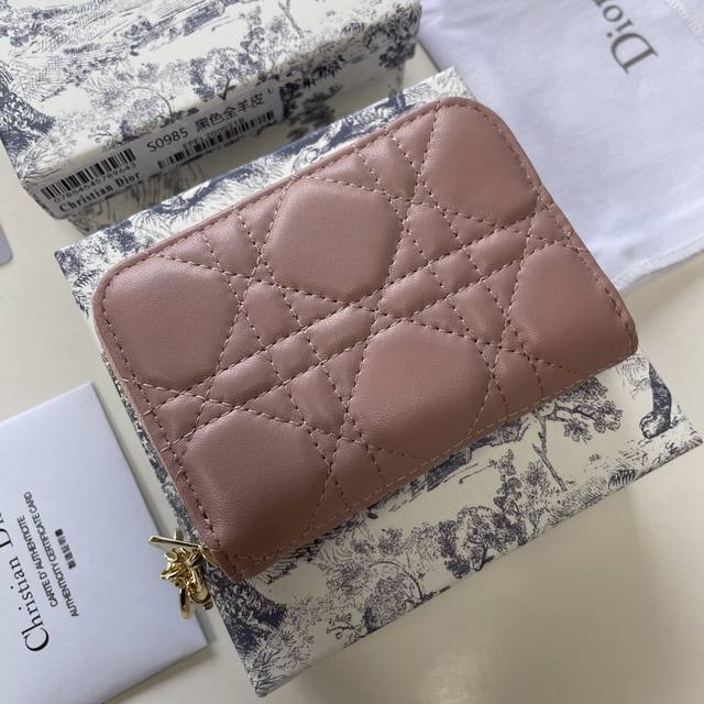 这款 Dior Caro 可拆卸卡夹精巧实用。采用柔软的粉色羊皮革精心制作，饰以标志性的藤格纹缉面线。搭配有金属吊坠，可挂在新款刺绣肩带上，点缀各式手袋。可放入