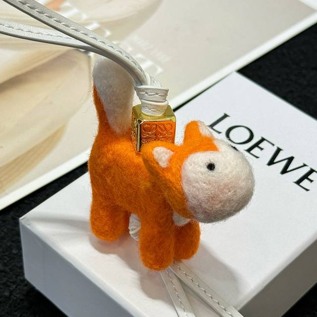 罗意威Loewe 毛毡和牛皮革小狐狸挂饰 挂件 颜色：橙色 毛毡小狐狸挂饰，连接有牛皮革环带和 Anagram骰子。挂饰为 LOEWE x Suna Fujit