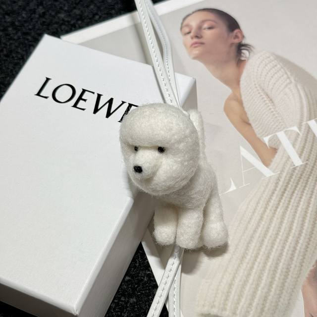 罗意威Loewe 毛毡和牛皮革贵宾犬挂饰 挂件 颜色：柔白色 毛毡贵宾犬挂饰，饰有Anagram骰子和牛皮革饰带 采用进口小牛皮 可挂于包包，其萌趣、可爱的造型