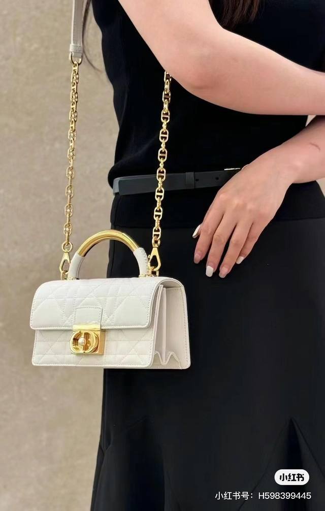 Dior Ange 手袋奶白色牛皮 超大藤格纹 以优雅时尚的美学风格开启 Dior 的全新系列 以超大藤格纹缉面线，硬挺的复古金色饰面金属顶部手柄镌刻以 Chr